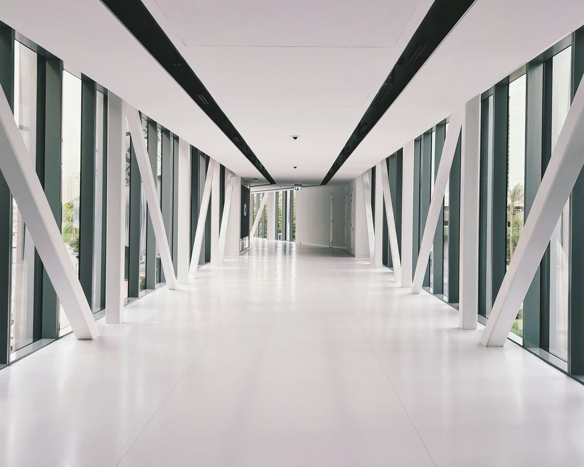 A bright architectural corridor lined with tall columns